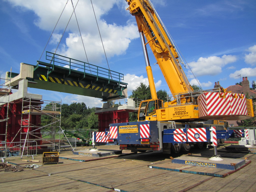 crane on temporary roadway lifting bridge section