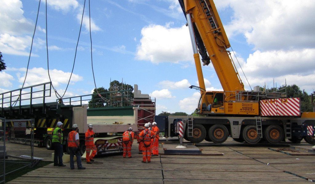 crane supported by crane mats lifting bridge sections