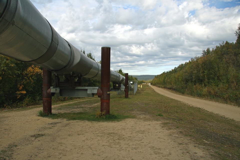 pipeline section suspended through field running past a tree line