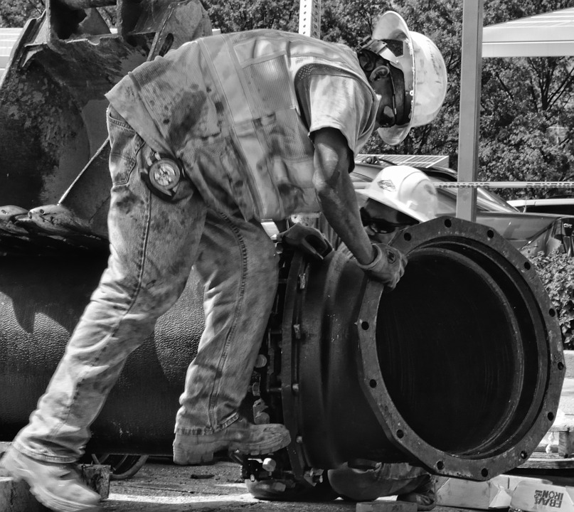 black and white pipeline maintenance workers in hard hat