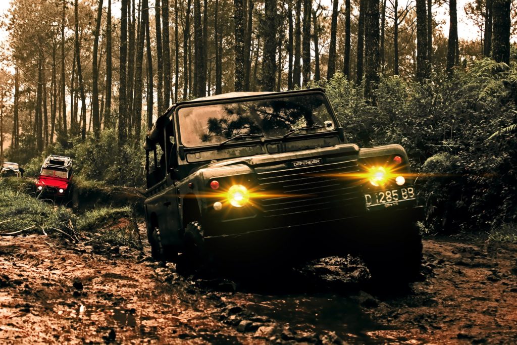 Land Rover on unstable ground and flooded mud within a forest