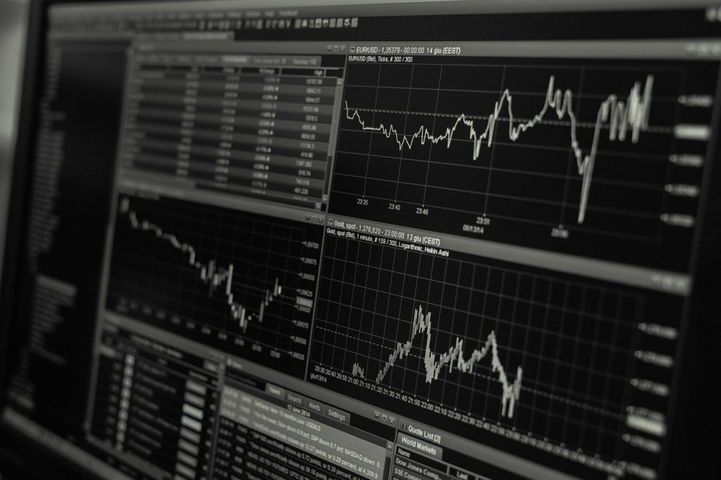 black and white screen with stock prices and charts showing fluctuations