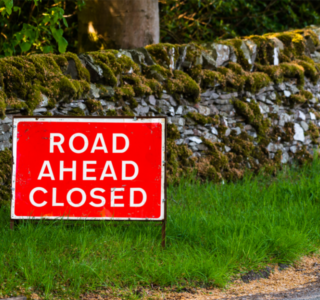 'road ahead closed' sign on the side of a country road in the uk
